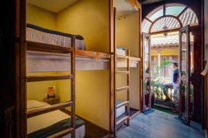 a room with bunk beds in a room with a window at The Clock Hostel & Suites in Cartagena de Indias