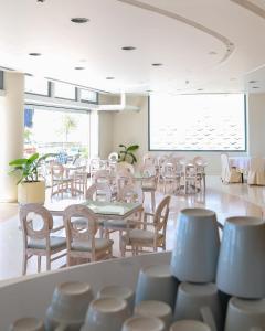 ネア・カリクラティアにあるAegean Blue Beach Hotelのテーブルと椅子、大きな窓のあるレストラン