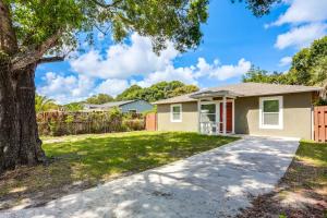 a house with a tree and a driveway at Pet-Friendly Fort Pierce Home 1 Mi to Downtown! in Fort Pierce