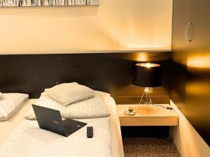 a hotel room with a bed with a laptop on it at Hotel Zlaté Košice in Košice