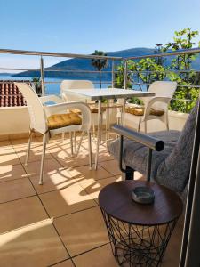 uma varanda com mesa e cadeiras e vista para o oceano em Boka Residence 8 em Herceg Novi