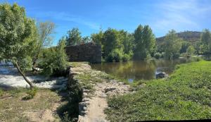 a river with a stone wall next to a river at Casa dos Araújos in Frechas