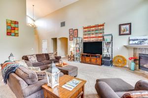 a living room with couches and a flat screen tv at Redmond Golf Getaway - Near Smith Rock State Park! in Redmond
