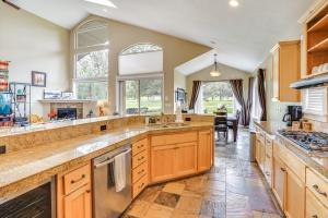 a large kitchen with wooden cabinets and counters at Redmond Golf Getaway - Near Smith Rock State Park! in Redmond