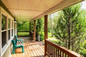 a porch with two green chairs on it at Very Private Cottage, Outdoor Hot Tub, BBQ, Petfriendly, 10 acres of Privacy! in Collingwood