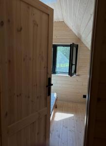 una puerta abierta a una habitación con dormitorio en Leśne Klimaty, en Smolniki