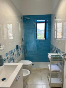 a blue bathroom with a toilet and a sink at Palazzo Sandù Dimora nel Borgo in San Nicola Arcella