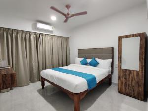 a bedroom with a bed with a ceiling fan at Hotel MJ baga in Calangute