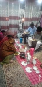 斯利那加的住宿－The Chinar Residency，一群坐在地板上吃食物的人