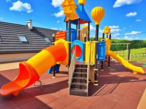 a colorful playground with a slide and a ladder at Zefirowe Wzgórze in Polańczyk