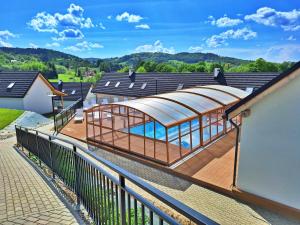a house with a deck with a glass roof at Zefirowe Wzgórze in Polańczyk