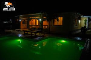 una casa con piscina iluminada por la noche en Shikari Luxville, en Vipingo