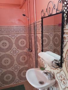 a bathroom with a sink and a mirror at Auberge Camping Garde of Eden LE LAC in Tinerhir