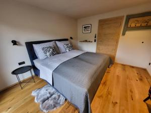 a bedroom with a large bed and a wooden floor at Going Living in Going am Wilden Kaiser