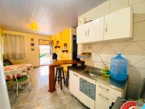 a small kitchen with a sink and a table at Pousada Inn Nature in Palhoça