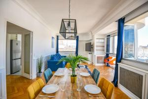 Un comedor con una mesa larga y sillas. en Vieux-Port - Vue exceptionnelle - 2 ch et clim, en Marsella