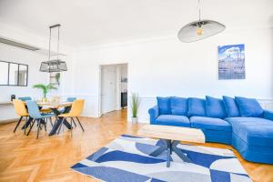 Una sala de estar con un sofá azul y una mesa. en Vieux-Port - Vue exceptionnelle - 2 ch et clim, en Marsella