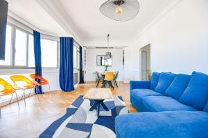 Una sala de estar con un sofá azul y una mesa. en Vieux-Port - Vue exceptionnelle - 2 ch et clim, en Marsella 16 fotos más