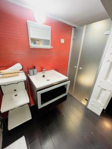 uma casa de banho com um lavatório branco e uma parede vermelha em Carretas dúplex exterior derecha em Madri