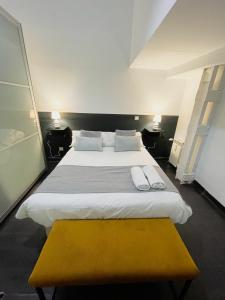 マドリードにあるCarretas dúplex exterior derechaのベッドルーム(大型ベッド1台、黄色のベンチ付)