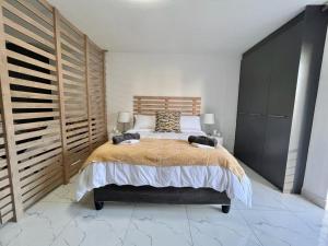 Un dormitorio con una cama grande con cabecero de madera. en Trendy Green Point Retreat, en Ciudad del Cabo 11 fotos más