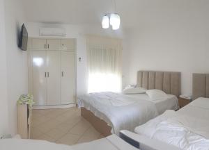 a bedroom with two beds and a tv in it at Vila Tirona in Durrës