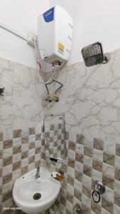 ein Badezimmer mit einem Waschbecken und einer Kamera an der Wand in der Unterkunft Maa kaushalya Guest House in Ayodhya in Ayodhya