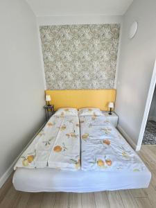a small bedroom with a bed with a yellow headboard at Przy plaży Apartament BURZA in Międzyzdroje