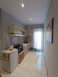 a kitchen with a stove and a refrigerator at Irene's home in Igoumenitsa