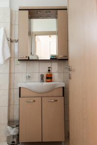 Ayiá的住宿－Melivoia Apartment，一间带水槽和镜子的浴室