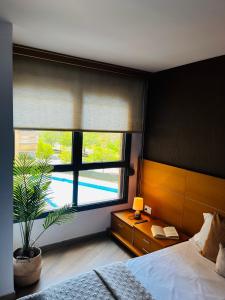 a bedroom with a bed and a window with a plant at Travel Habitat - Ciudad de las Ciéncias in Valencia
