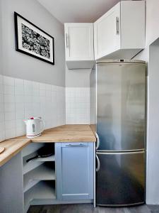 cocina con armarios blancos y nevera en Przy plaży Apartament BURZA, en Międzyzdroje