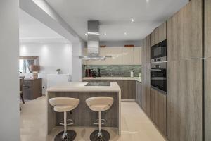 a kitchen with a counter and stools in a kitchen at Anastasia maisonette sea view in Kontokali