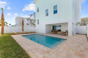 une maison avec une piscine en face d'une maison dans l'établissement Ocean Retreat Pool, Bbq, Short Walk To Beach, à Saint Augustine Beach