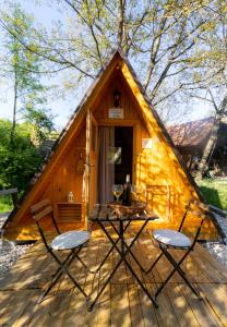 a picnic table and chairs in front of a triangular house at Apartma Judita in Glamping Luna in Bled