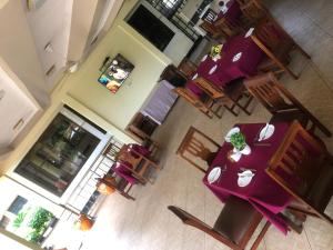 einen Blick über einen Speisesaal mit lila Tischen und Stühlen in der Unterkunft CBA Hotel in Tanga