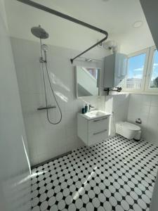 een witte badkamer met een douche en een wastafel bij Luxury Central Apartment Easy Kaunas in Kaunas