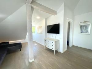 een witte woonkamer met een televisie en een bank bij Luxury Central Apartment Easy Kaunas in Kaunas