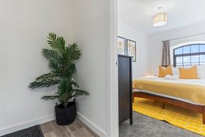 Un dormitorio con una cama y una palmera. en New 2 Bedroom Apartment in Burton en Burton upon Trent