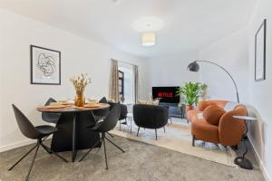 ein Esszimmer und ein Wohnzimmer mit einem Tisch und Stühlen in der Unterkunft New 2 Bedroom Apartment in Burton in Burton upon Trent