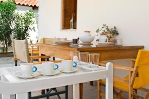 una mesa con tazas y platos encima en traditional village house, en Ariokhórion