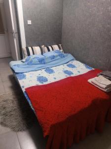 ein Bett mit einer roten und blauen Decke drauf in der Unterkunft În Buna Ziua in Cluj-Napoca