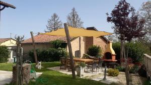 BIAMICI - casa de vacanze in Mombercelli في Mombercelli: مظلة صفراء في الحديقة الخلفية للمنزل