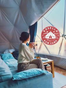 ワディ・ラムにあるRosella rum campのテントのベッドに腰掛けている女性