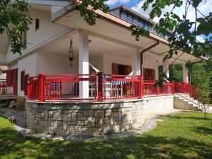 una casa con una recinzione rossa e un muro di pietra di Casa BnB Pappappero Monti della Laga a Fioli