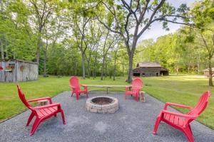 a group of red chairs around a fire pit at Restored Buchanan Log Cabin on 9-Mile Creek! in Reba