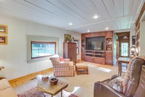 a living room with a couch and a tv at Restored Buchanan Log Cabin on 9-Mile Creek! in Reba