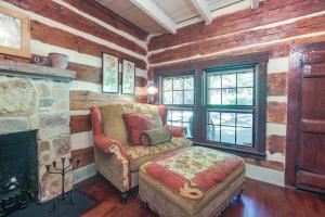- un salon avec une chaise et une cheminée dans l'établissement Restored Buchanan Log Cabin on 9-Mile Creek!, à Reba