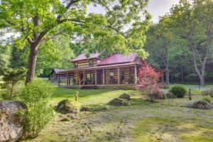 eine Blockhütte im Wald mit einem Hof in der Unterkunft Restored Buchanan Log Cabin on 9-Mile Creek! in Reba