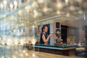 a woman is drinking a cup of coffee at Park Hyatt Mendoza Hotel, Casino & Spa in Mendoza